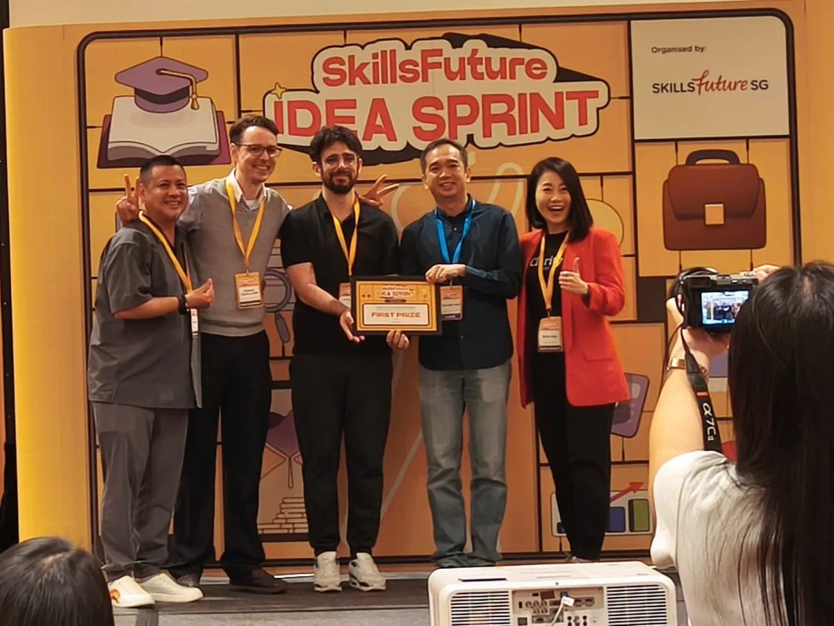 The team holding the award in front of the Idea Sprint backdrop.